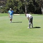 John Elliott putts as John O'Connor looks on